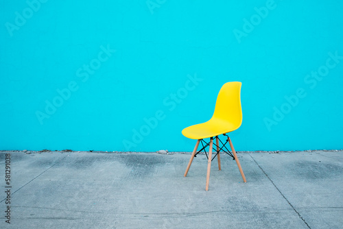 Empty yellow chair on a blue wall, complementary colors