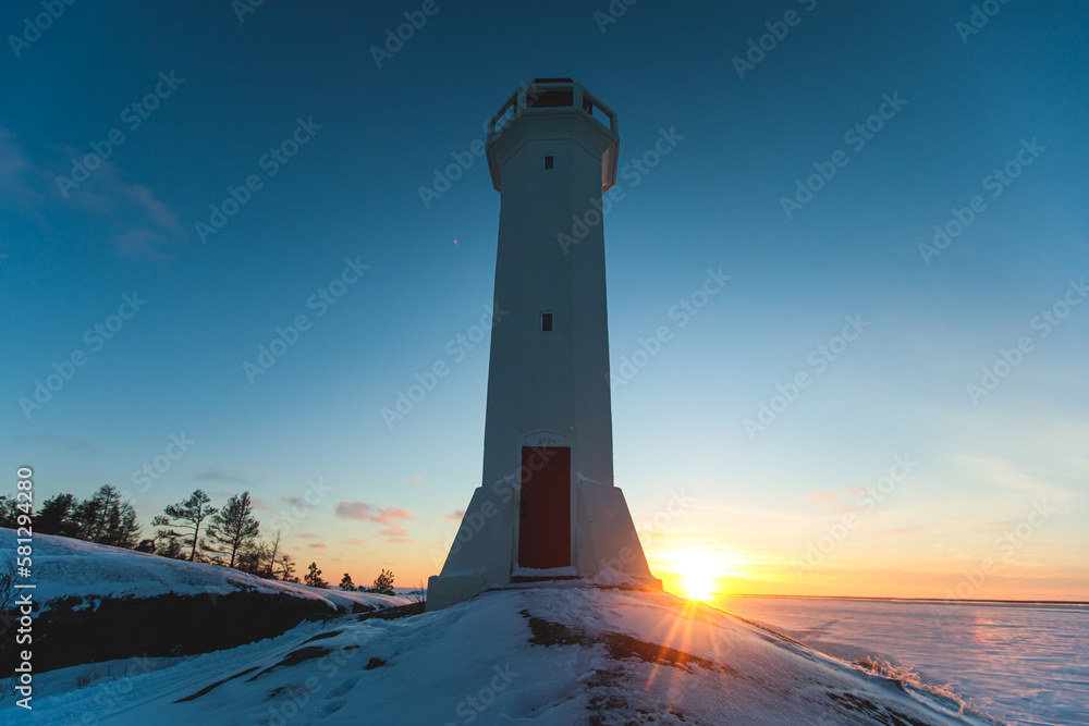 Snowy view of Povorotny lighthouse, Vikhrevoi island, Gulf of Finland, Vyborg bay, Leningrad oblast, Russia, winter sunny day with a blue sky, lighthouses of Russia travel