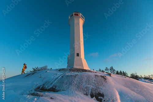 Snowy view of Povorotny lighthouse, Vikhrevoi island, Gulf of Finland, Vyborg bay, Leningrad oblast, Russia, winter sunny day with a blue sky, lighthouses of Russia travel photo