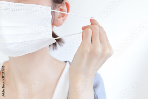 マスクを外す女性の手元 photo