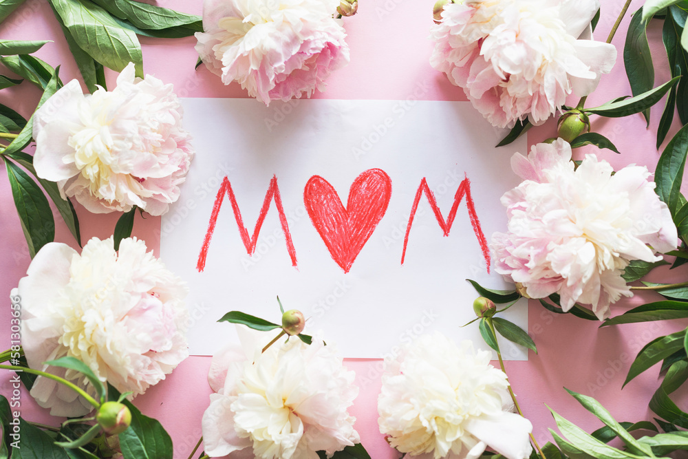 Happy Mothers Day. Fresh peonys and postcard for mom on pink background. Stylish greeting card. Greeting card template with text