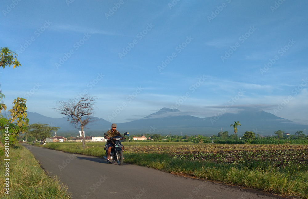 A woman rides a motorbike on a country road