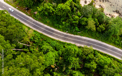 Aerial view of empty road with green forest