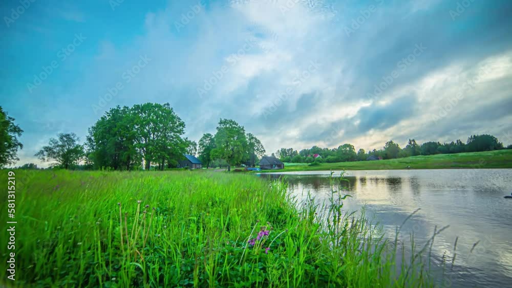 Extreme fast time lapse wide angle houses on a small lake in green meadow Extreme fast time lapse wide angle houses on a small lake in green meadow