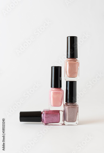 Nail polish of light shades of the pyramid stands on a white table. Isolates. White background