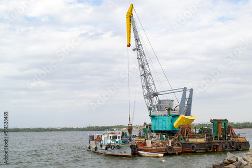 Luffing crane at the barge on water