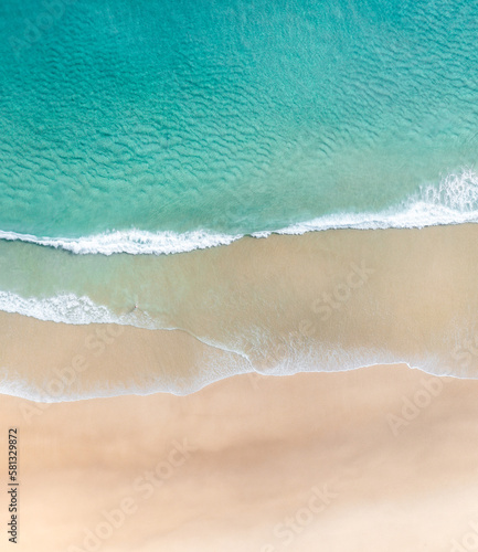 Aerial view of a beach with gentle waves and white sand in a tropical wonderland © FRPhotos