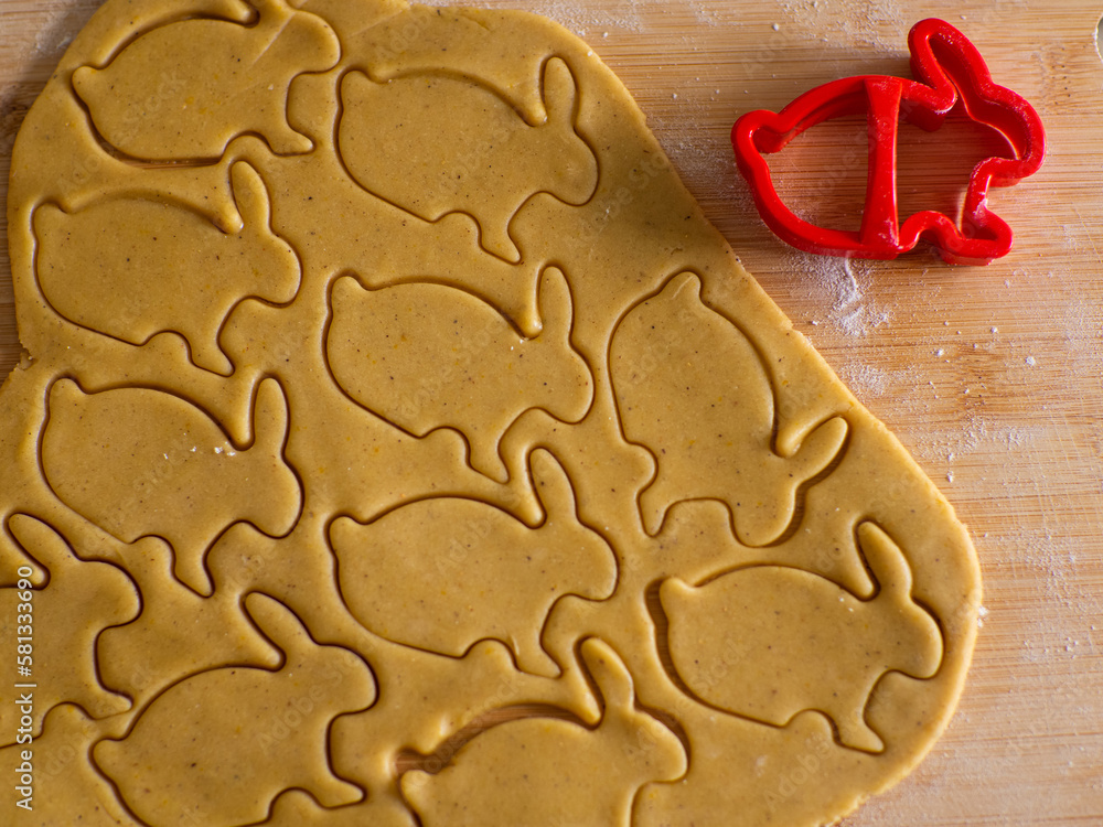 Close-up kneaded ginger dough and carved figurines from it. The shapes of rabbit. Cutting sugar cookie dough with Easter shaped cookie cutters. Preparation for Easter. Holidays baking. Close-up kneaded ginger dough and carved figurines from it. The shapes of rabbit. Cutting sugar cookie dough with Easter shaped cookie cutters. Preparation for Easter. Holidays baking.