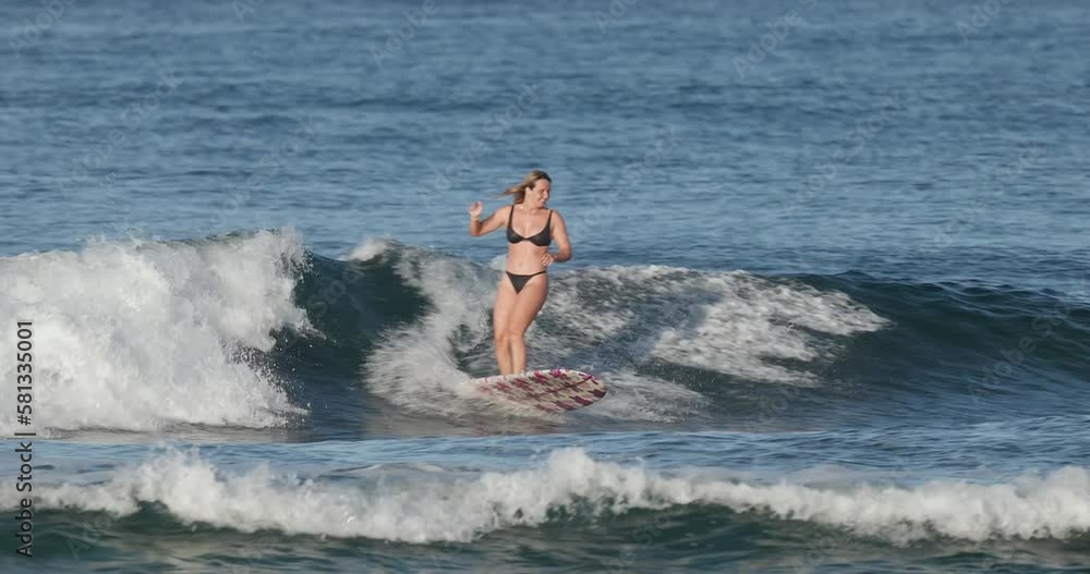Young woman surf on a longboard in the ocean in Hawaii Honolulu Young woman surf on a longboard in the ocean in Hawaii Honolulu