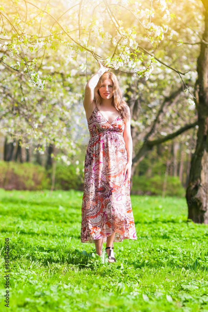 Modern Lifestyle Concepts. Portrait of Winsome Blond Caucasian Adult Girl Posing Outside in Green Forest With Lifted Hand. Modern Lifestyle Concepts. Portrait of Winsome Blond Caucasian Adult Girl Posing Outside in Green Forest With Lifted Hand.