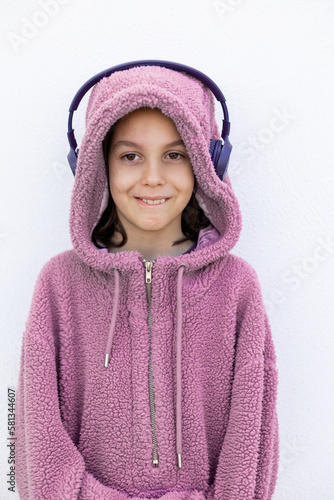 teenager in headphones and a purple hidi is standing on the street. Stylish boy. photo