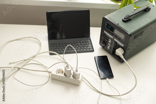 Portable power station charging gadgets near wall