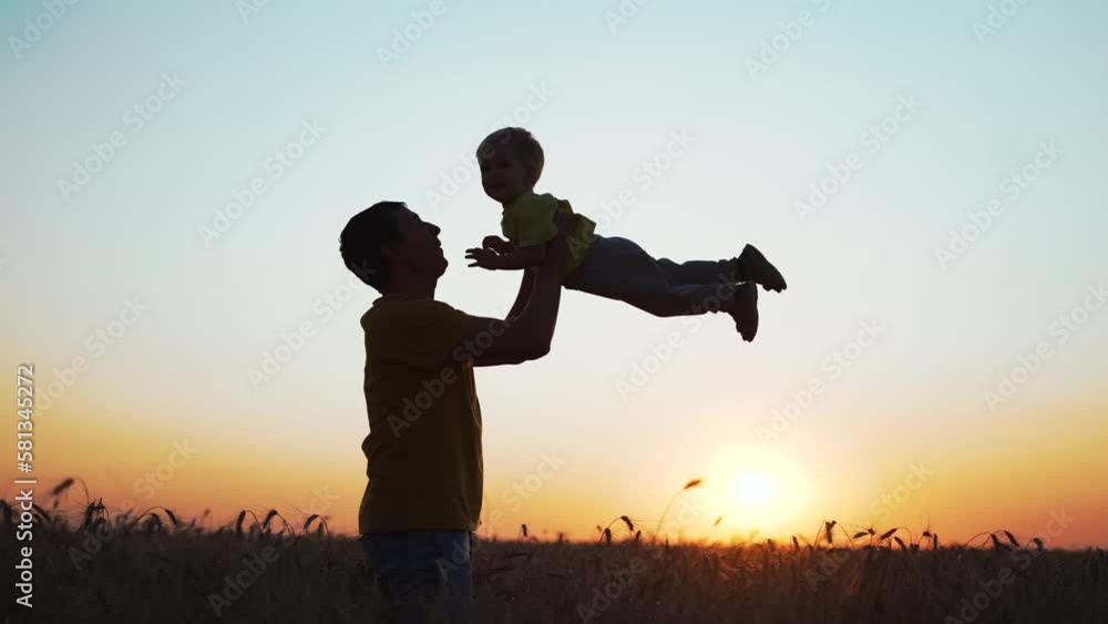 Happy family. Father throws his son up into sky. Silhouette of people