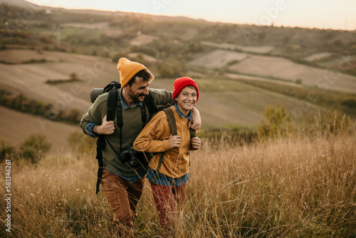 Fotografie Father and son talking while walking in the golden hills.
