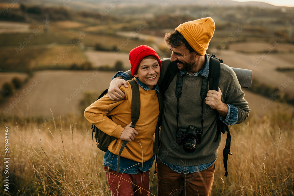 Father and teenage son together hiking on the hills: outdoor adventure Father and teenage son together hiking on the hills: outdoor adventure