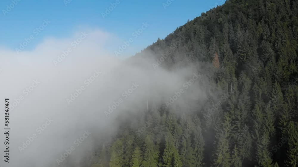 High above clouds mountain top aerial. Drone fly above mist clouds in forest covered mountain area Europe High above clouds mountain top aerial. Drone fly above mist clouds in forest covered mountain area Europe