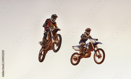 Fototapeta Naklejka Na Ścianę i Meble -  Hes tryna jump into an early lead. A shot of two motocross riders in midair during a race.