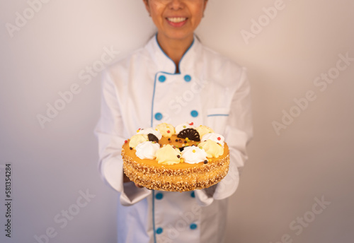 Unknown latin woman chef shows off a splendid cake fresh out of the oven