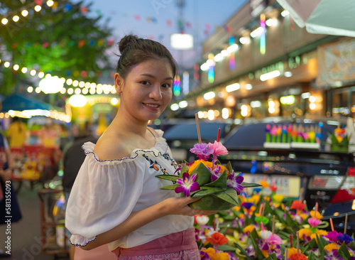 Canvas Print Portrait of Asian Thai woman with Loy Krathong in Thailand , floating on water in local street market festival