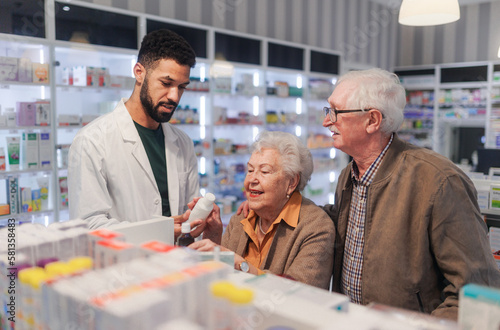 Young pharmacist helping senior couple to choos medication.