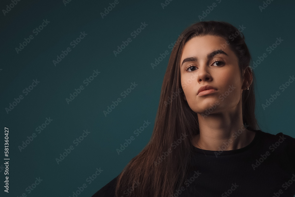 Portrait of young woman in studio, dark blue background. Portrait of young woman in studio, dark blue background.