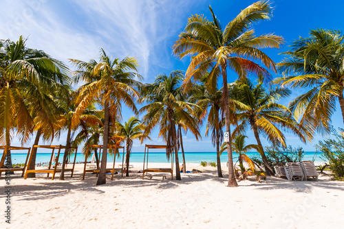 Tropical paradise beach with white sand and coco palms travel tourism wide panorama background. Luxury vacation and holiday, tropical beach resort concept. Beautiful beach design