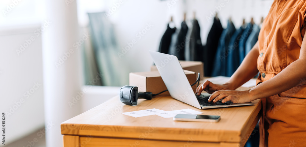© (JLco) Julia Amaral - Online store owner using a laptop in her shop © (JLco) Julia Amaral - Online store owner using a laptop in her shop