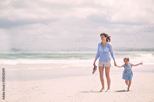 Taking a stroll on the beach. young mother and her daughter going for a walk along the beach.