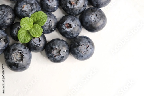 Fresh blueberries with mint leaves. The fruits are actual berries with many tiny seeds and are deep indigo to black color when ripe. Copy space.
