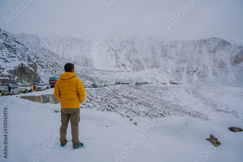 The man is posing at Khardung La pass, the highest (5,359 m, 17,582 ft) motorable pass on the world, in a snow storm. Ladakh, Jammu and Kashmir, India photo
