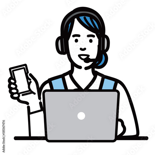 ラップトップの前に座ってスマホを持って笑顔で説明をしているオペレーターの若い女性
