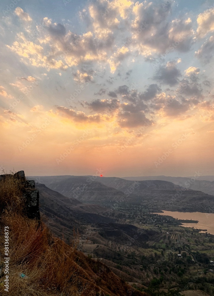 Obraz premium Beautiful view of the sunset and mountains from Sajjangad, satara, Maharashtra, India. Koyana dam backwater view from sajjangad.