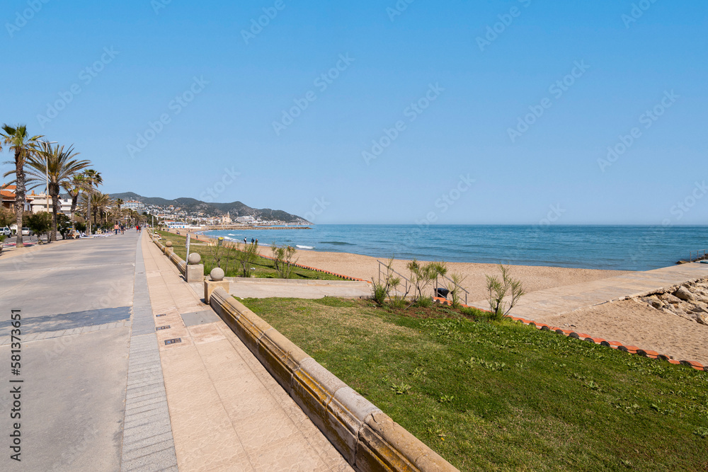 Fascinating view of the promenade on the backdrop of the sea and mountains and palm trees on sunny warm summer day. Concept of beach area in tourist city during a holiday. Copyspace