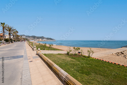 Fascinating view of the promenade on the backdrop of the sea and mountains and palm trees on sunny warm summer day. Concept of beach area in tourist city during a holiday. Copyspace © Pavel