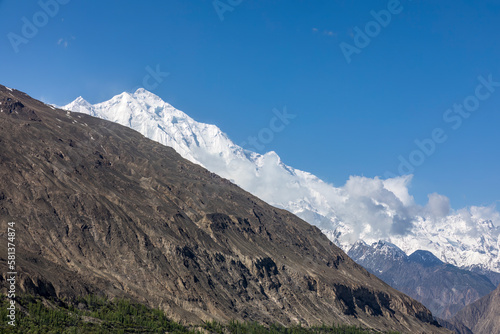 Contrasting mountains with blue sky. Barren and snow covered mountains with blue sky.