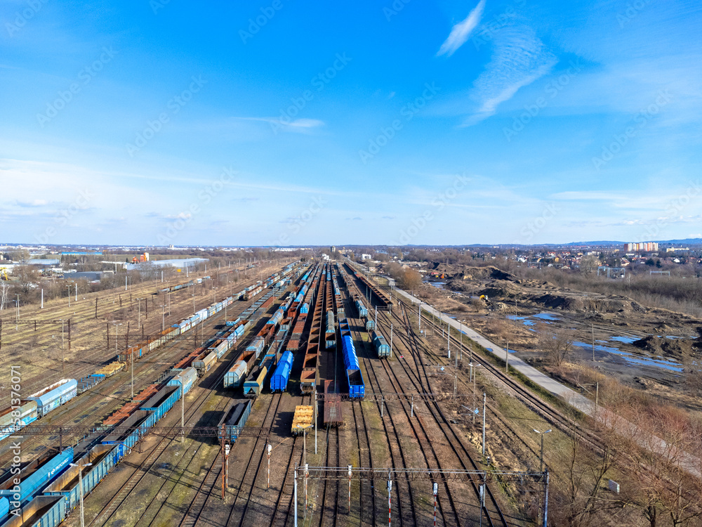 Aerial view landscape. View of railroad tracks and trains, cars, cargo. Blue sky.