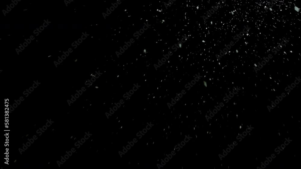 Real falling snowflakes out of focus on black background for overlay blending mode. White snow against black night sky in the winter. Real falling snowflakes out of focus on black background for overlay blending mode. White snow against black night sky in the winter.