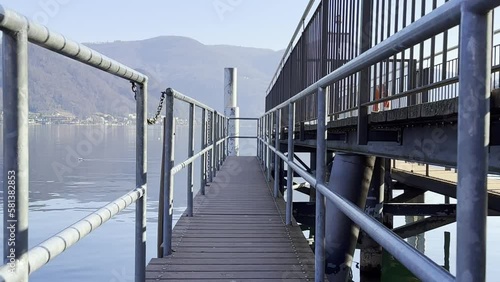 Pier on Alpine Lake Lugano and Mountain in a Sunny Day in Caslano, Ticino in Switzerland. photo