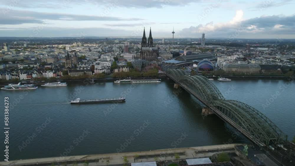 Inland tanker sailing under the green Hohenzollernbrücke with the skyline of Köln in the background. Drone lowering panning shot Inland tanker sailing under the green Hohenzollernbrücke with the skyline of Köln in the background. Drone lowering panning shot
