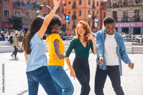 Multiethnic young friends dancing in a city square  group dancers having fun to music