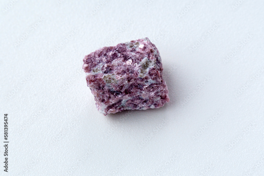 Lepidolite stone on a white background, being a secondary source of lithium, used in batteries Lepidolite stone on a white background, being a secondary source of lithium, used in batteries