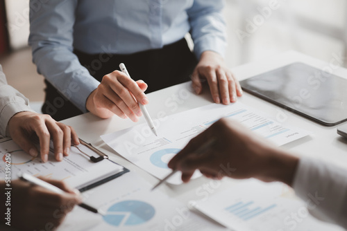 Company meeting room has businessmen and finance managers meeting together on finance topics, they are looking at information on documents and discussing together. Concept company financial management