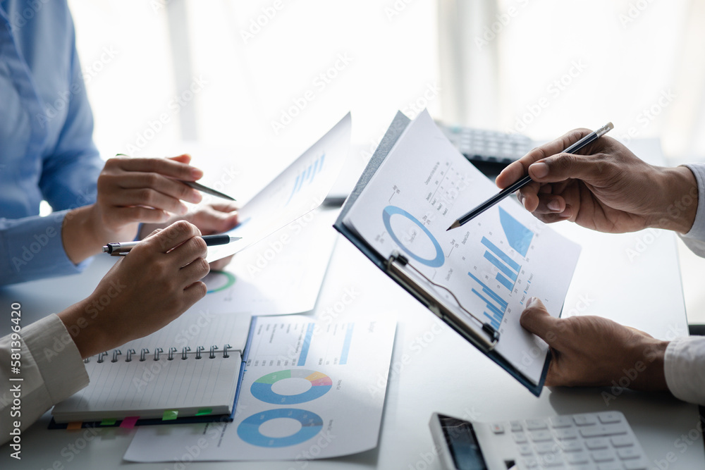 Company meeting room has businessmen and finance managers meeting together on finance topics, they are looking at information on documents and discussing together. Concept company financial management Company meeting room has businessmen and finance managers meeting together on finance topics, they are looking at information on documents and discussing together. Concept company financial management