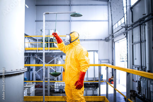 Safety at work. Occupational health and safety regulations. Worker in chemicals production plant taking a shower after accident washing away the acid.