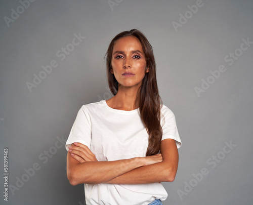 Portrait of serious caucasian woman wearing white tshirt on grey background