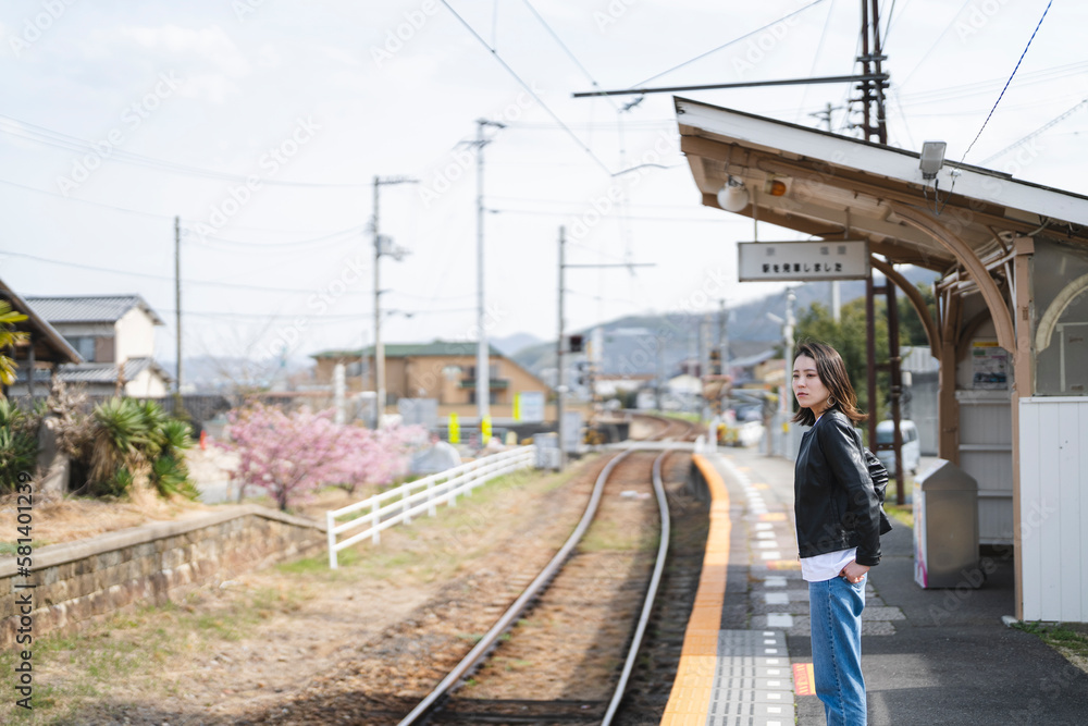 Naklejka premium ローカル線の無人駅にいる女性