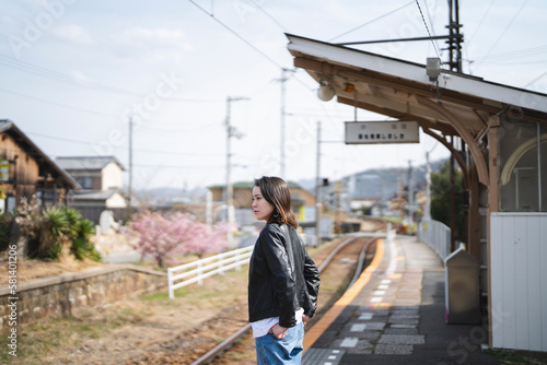 ローカル線の無人駅にいる女性