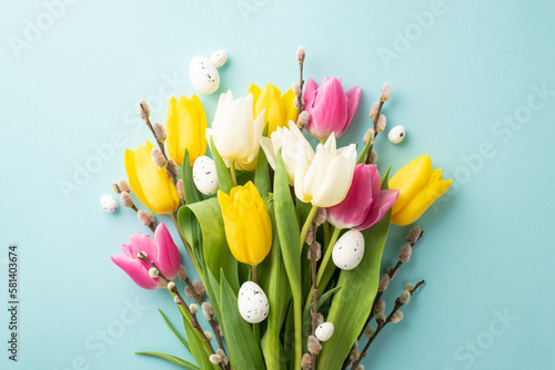 Easter aesthetic concept. Top view photo of bouquet of pink white yellow tulips pussy willow branches and eggs on isolated pastel blue background #581403674
