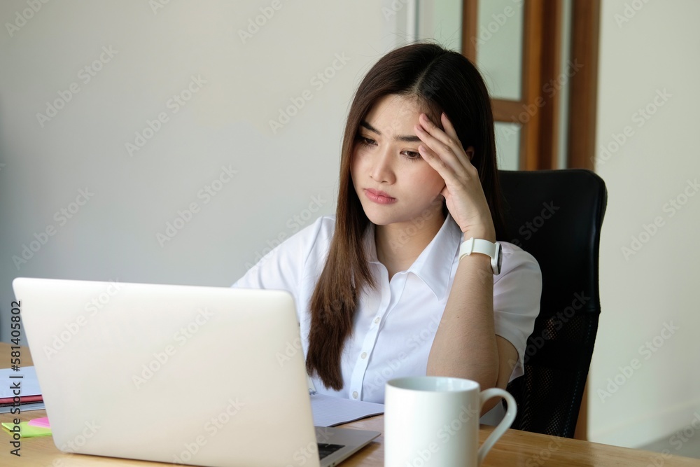 Asian women are stressed while working on laptop, Tired asian businesswoman with headache at office, feeling sick at work, copy space Asian women are stressed while working on laptop, Tired asian businesswoman with headache at office, feeling sick at work, copy space