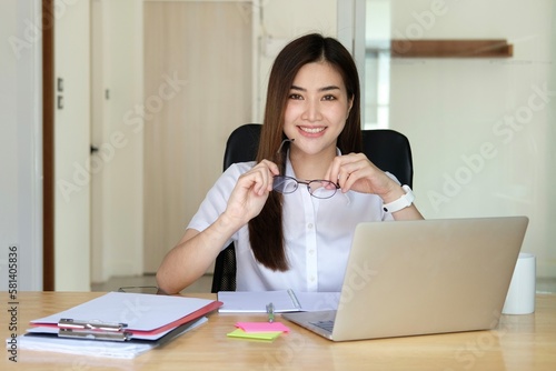 Photography Young Asian entrepreneur working from her laptop
